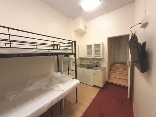 a bedroom with a bunk bed and a kitchen at Center of Helsinki 1 in Helsinki