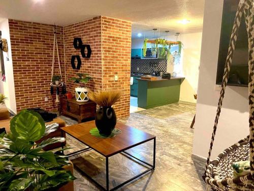 a living room with a table and a brick wall at Planta Baja Enorme, Jardín, Parking, Hasta 11 Pax in Guadalajara