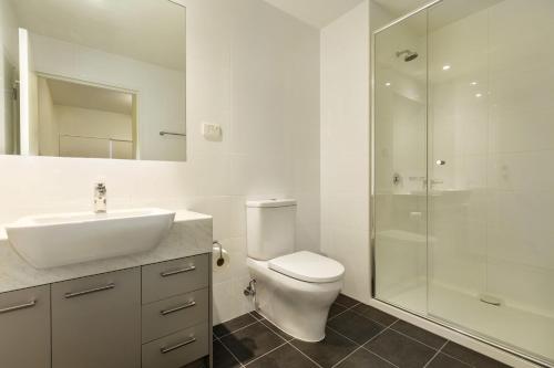 a bathroom with a toilet and a sink and a shower at Quest Melbourne Airport in Melbourne