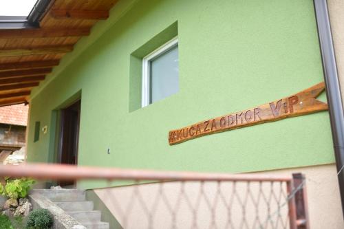 ein Schild an der Seite eines grünen Hauses in der Unterkunft Kuca za odmor ViP in Kremna