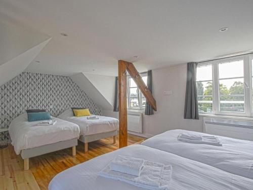 una camera con due letti e due finestre di Holiday Home in the heart of Calvados with Terrace a Isigny-sur-Mer