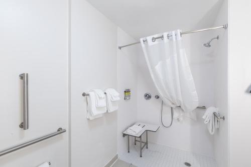 a white bathroom with a shower and a shower curtain at Holiday Inn Express & Suites Columbia Downtown The Vista by IHG in Columbia