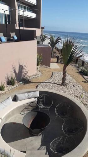 a patio with three chairs and a fire place at Luxury Beach Condo with Pool in Tijuana