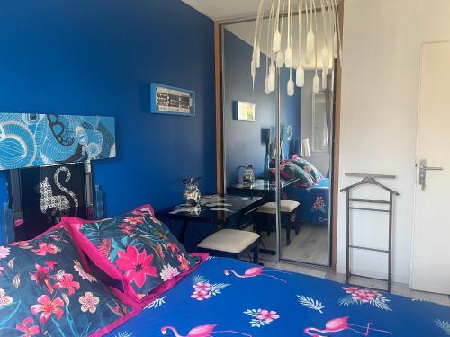 niebieska sypialnia z łóżkiem i lustrem w obiekcie ELLO HAPPINESS HOME place to be in pau w mieście Pau