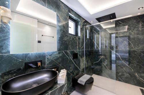 a bathroom with a black sink and a mirror at Toska Tower in Chrysi Ammoudia