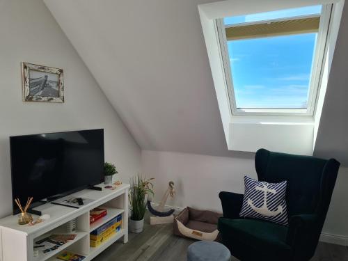 a living room with a flat screen tv and a window at Ferienwohnung LOUISE in Dreschvitz