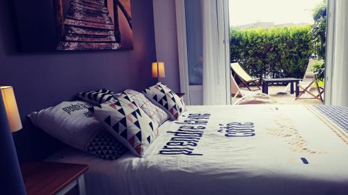a bedroom with a bed with a sign on it at Agréable T3 avec jardin et parking privé, à 350m du centre ville et des plages, wifi, remise supplémentaire de 10 pourcent pour une location à la semaine in Cavalaire-sur-Mer