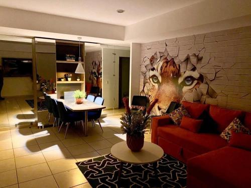 a living room with a red couch and a table at Diseño Único Con 2 Recámaras, Alberca Y Gimnasio in Guadalajara
