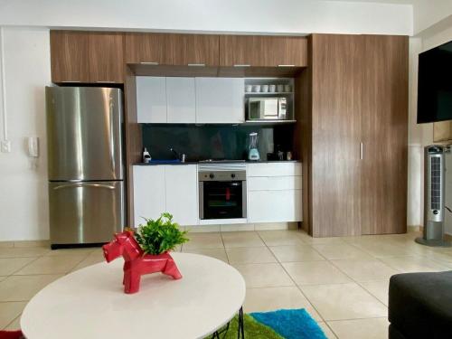 a kitchen with a table and a refrigerator at 2 BEDROOMS WITH POOL, GYM, 24 HOURS SECURITY, 7 PEOPLE in Guadalajara