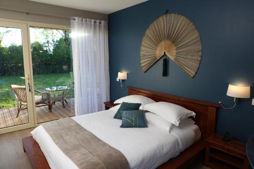 a bedroom with a bed with a large fan on the wall at La Transparence in Mazaye