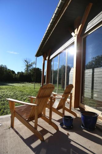 two wooden chairs sitting on the porch of a house at La Transparence in Mazaye