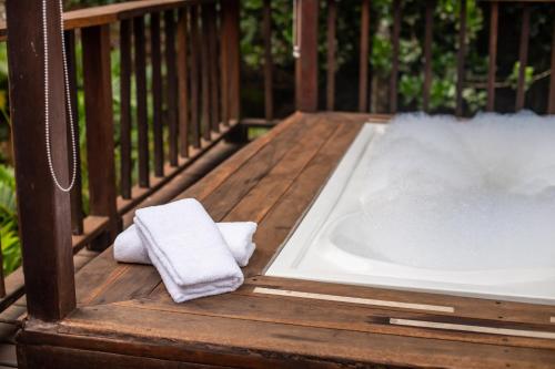 a bath tub sitting on a deck with a towel at Hotel MadreSierra Parque Tayrona in Calabazo