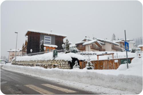 a house is covered in snow on a street at Hotel Villa Argentina Ronzone in Ronzone