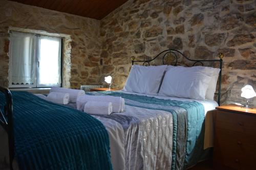 a bedroom with a bed with towels on it at Casa da Pedra in Ansião