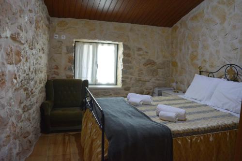 a bedroom with a bed and a chair and a window at Casa da Pedra in Ansião