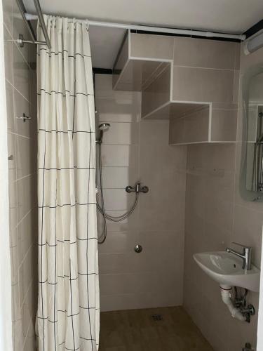 a bathroom with a shower curtain and a sink at Apartment Vesna in Skradin