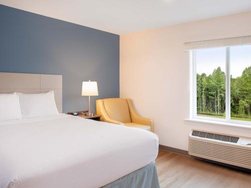 1 dormitorio con 1 cama, 1 silla y 1 ventana en Extended Stay America Suites - Charlotte - Matthews, en Charlotte