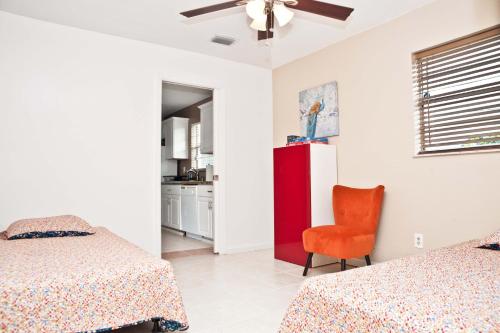 una camera con due letti e una sedia rossa di The perfect escape from the Big City a Port Saint Lucie