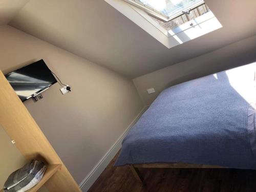 1 dormitorio en el ático con cama y ventana en Mornington Harrogate en Harrogate