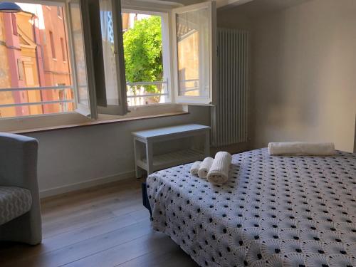 a bedroom with a bed and two windows at Cielo Apartment in Forlì