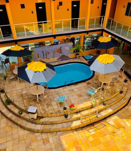 an overhead view of a swimming pool with umbrellas at Pousada Beira Mar in Pitimbu