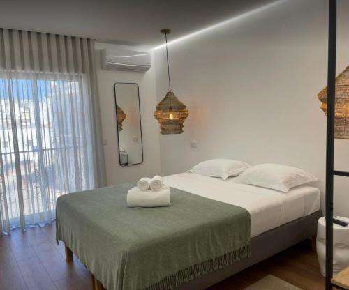 a bedroom with a bed with two towels on it at Pontinha Exclusive House in Faro