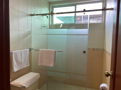 a bathroom with a glass shower with a toilet at DORAL SUITE ¡CERCA DEL AEROPUERTO! in Guayaquil