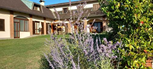a garden with purple flowers in front of a house at Villa Pieve in Moncalvo