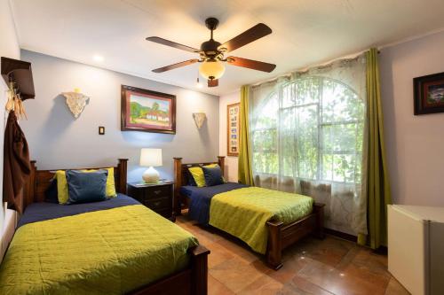 um quarto com 2 camas e uma ventoinha de tecto em XIN Bed&Breakfast em San José
