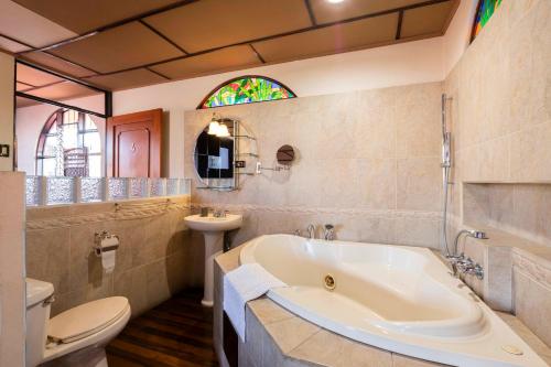a bathroom with a tub and a toilet and a sink at XIN Bed&Breakfast in San José