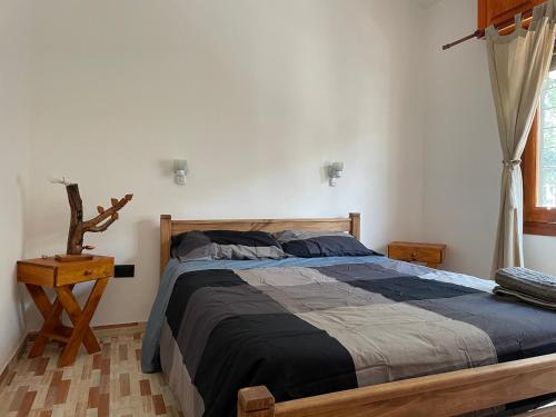 1 dormitorio con 1 cama grande con marco de madera en Casa Las Moras en San Antonio de Arredondo