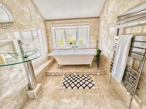 ein Bad mit einer Badewanne, einem Waschbecken und einem Fenster in der Unterkunft B43 Great Location Near Bhm City-Free Parking- Free WiFi- Near Villa Park in Holly Lane