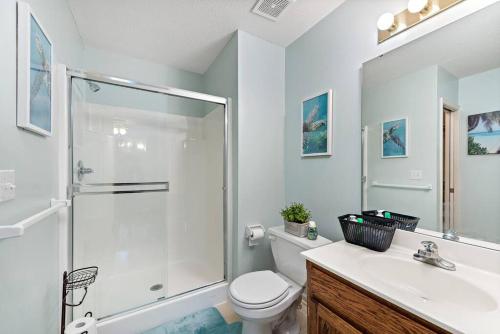 a bathroom with a shower and a toilet and a sink at Beautiful Townhome, 11 minutes to Downtown, KCMO. in Kansas City