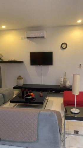 a living room with a flat screen tv on the wall at JACO BAY in Jacó