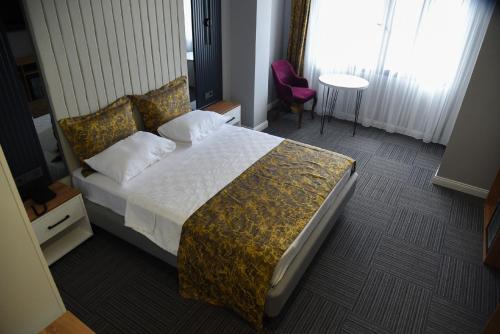 um quarto de hotel com uma cama e uma cadeira em çepnis hotel em Samsun
