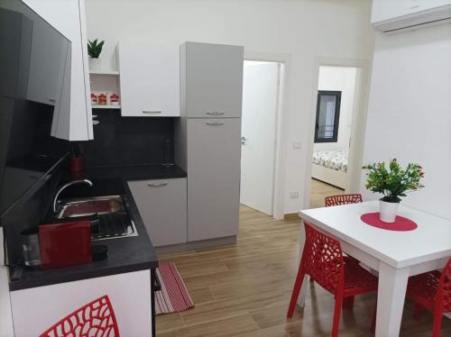 a kitchen with white cabinets and a table and chairs at Eraclea Minoa Apartments in Eraclea Minoa