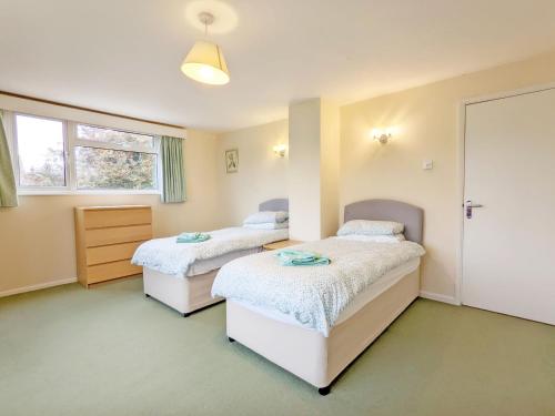 a bedroom with two beds and a window at Still Waters, Emsworth in Emsworth