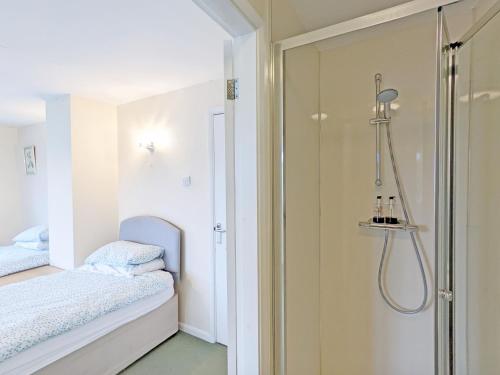 a bathroom with a shower and a bed at Still Waters, Emsworth in Emsworth