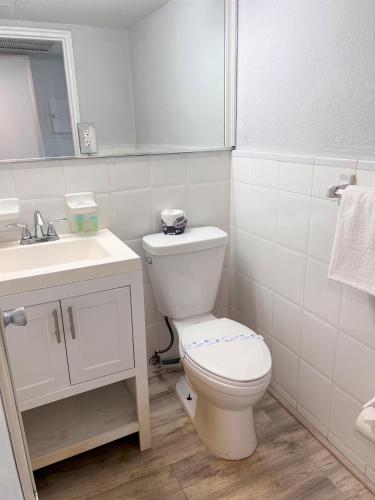 a white bathroom with a toilet and a sink at Ocean Front Units at Miami Beach in Miami Beach