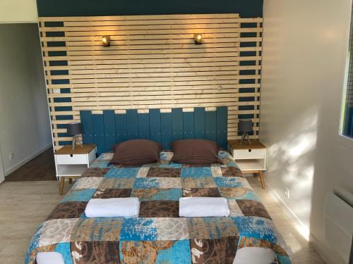 a bedroom with a large bed with two night stands at Cabane de pêcheurs avec spa au pied de l'étang in Hédé