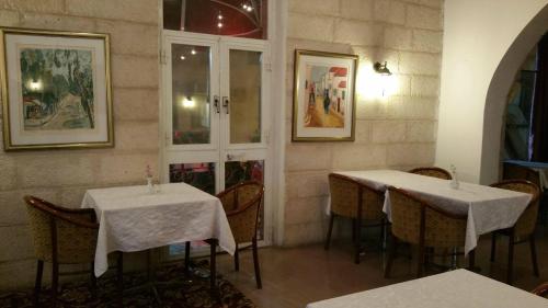 two tables in a restaurant with white table cloth at Zion Hotel in Jerusalem