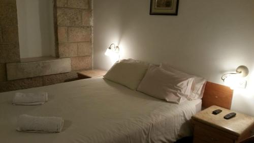 a bedroom with a white bed with two lights on it at Zion Hotel in Jerusalem