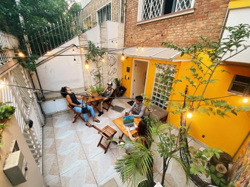 a group of people sitting at a table in a courtyard at Lamparina Hostel in Sao Paulo