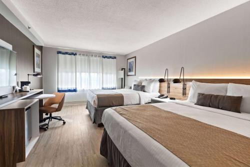 um quarto de hotel com duas camas e uma secretária em Wyndham Garden Manassas em Manassas