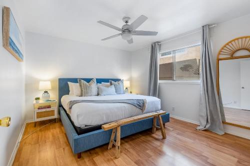 a bedroom with a blue bed and a ceiling fan at San Clemente Shores in San Clemente