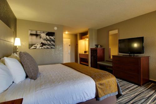 a hotel room with a bed and a flat screen tv at Best Western Harbour Pointe Lakefront in Saint Ignace