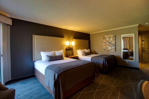 a hotel room with two beds and a mirror at Best Western Harbour Pointe Lakefront in Saint Ignace