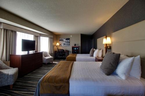 a hotel room with two beds and a television at Best Western Harbour Pointe Lakefront in Saint Ignace