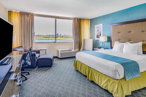 a hotel room with a large bed and a television at Wyndham Garden Kenosha Harborside in Kenosha