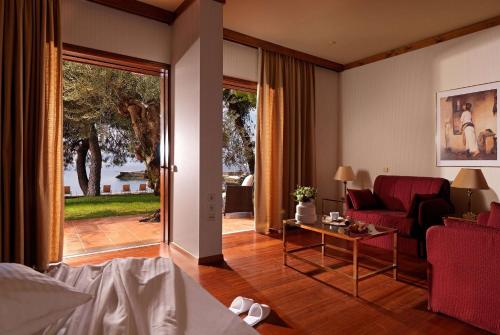a living room with a red couch and a table at Wyndham Loutraki Poseidon Resort in Loutraki